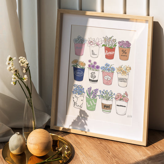 Framed artwork of potted plants on a wooden surface with a soft light background
