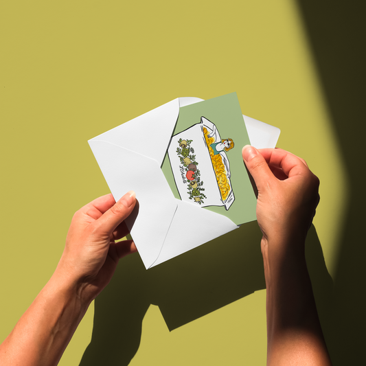 Hands holding a card with a colorful design against a green background