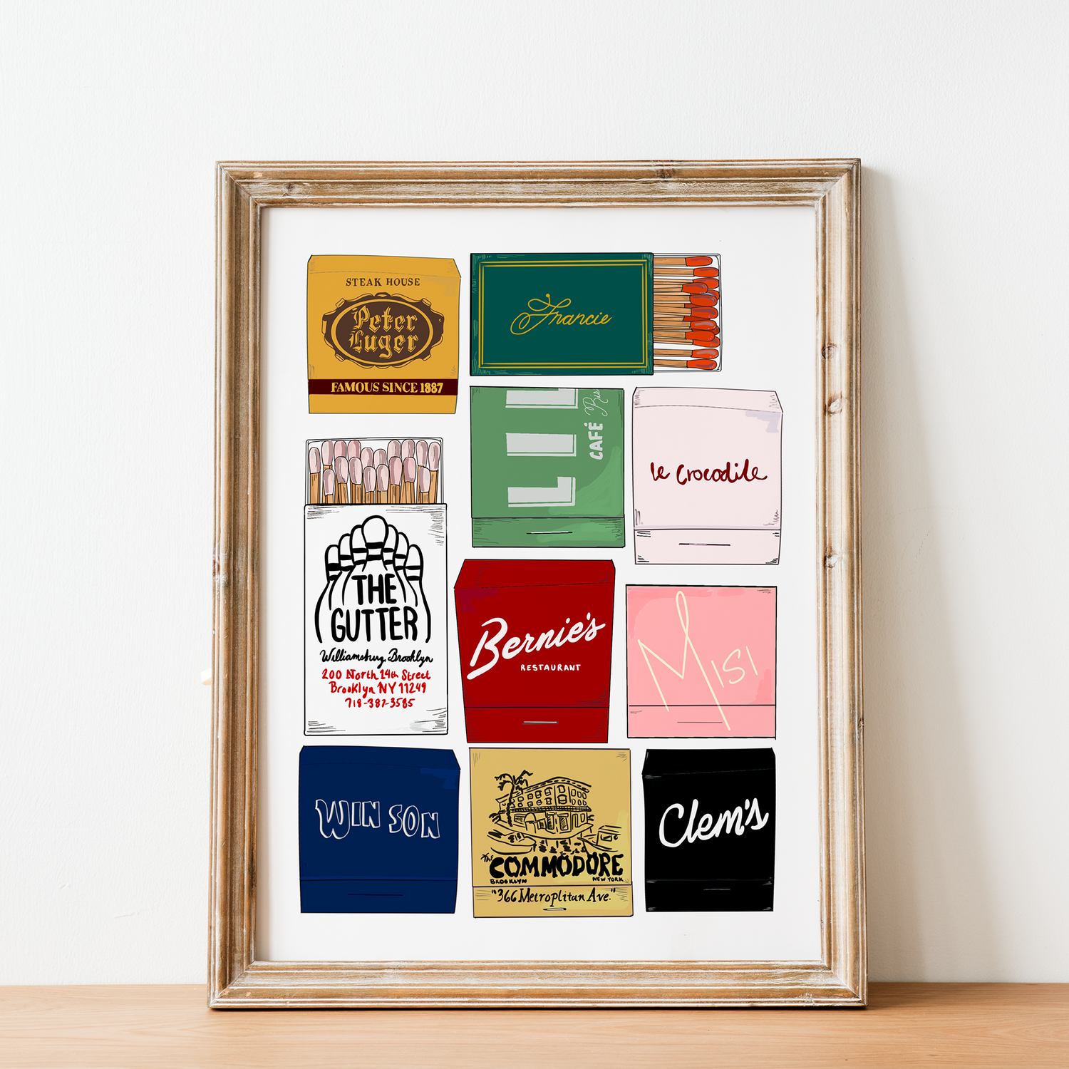 Framed collection of vintage matchbook covers on a white wall